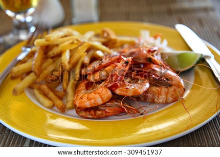 Shrimp and chips on the yellow plate, shallow focus
