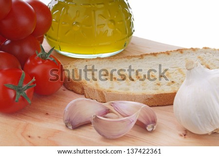 tomatoes garlic oil and brad on wooden table