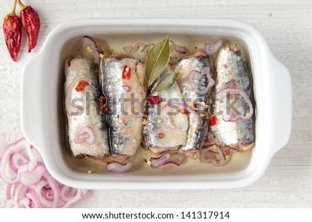 fish in ceramic pan with oil onion and chili