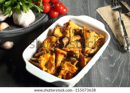cooked chanterelles  in white ceramic pan gray background
