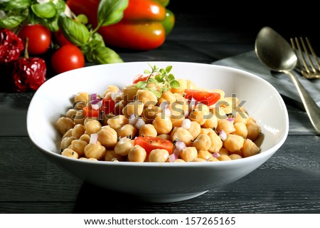 chickpeas salad in white bowl black background