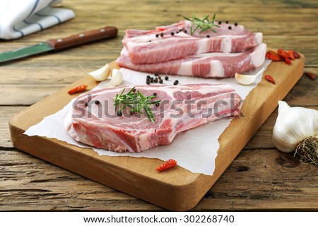 Top view raw pork chop steak  on wooden background.