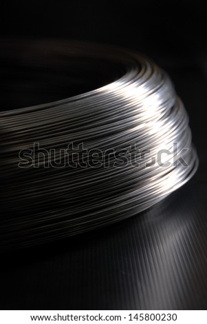 Steel wire in a coils on the dark background vertical