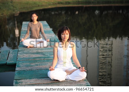 Peaceful 2; Asian are both women peaceful on the Lake, Bangkok, Thailand