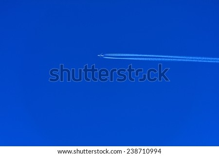 A plane flying on a perfectly blue sky with Vapor Trail