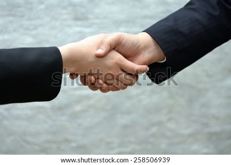 Close-up image of a firm handshake withe man and women