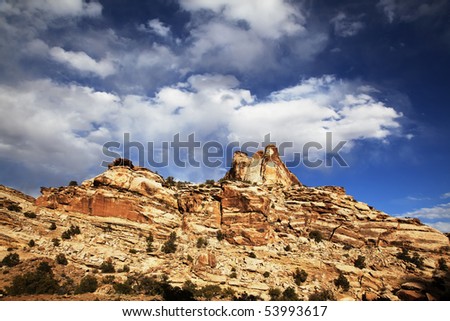 View of the red rock formations in San Rafael Swell with blue sky and clouds