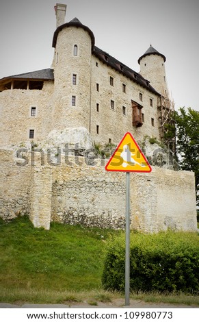 Bobolice castle and road sign with ghost. Orle Gniazda - Krakowsko Czestochowska highland
