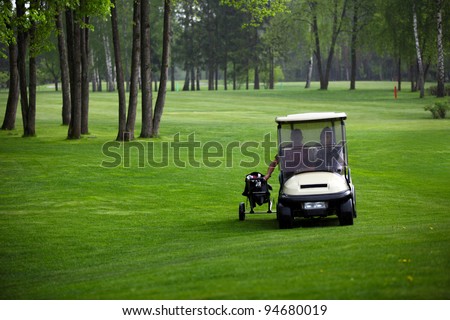 Two golfers escapes from the rain via golf car