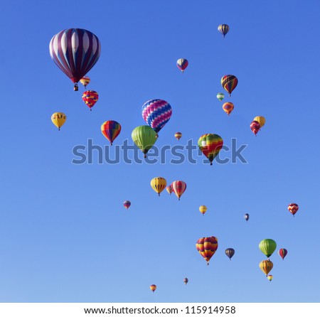 Many colorful hot air balloons in blue sky at balloon fiesta