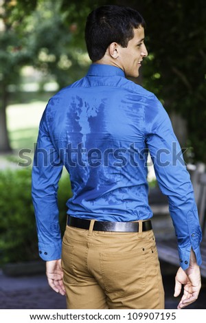 A sexy, masculine guy is showing sweat on his back./Sweat