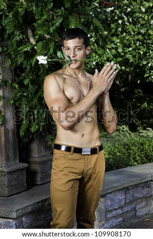 Keeping a rose in his mouth, a sexy, masculine young guy is standing there, clapping his hands...¦/Bachelor