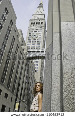 A professional woman is seriously standing in a business district/Portrait of a professional woman