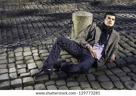 A young guy is lay on the ground, hopefully looking up./Waiting Outside