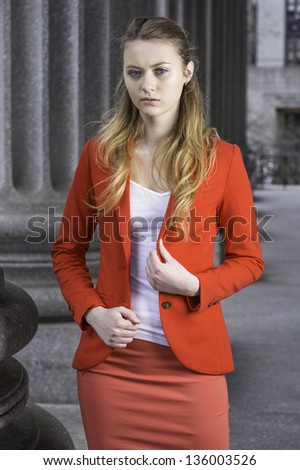 Dressing a red blazer and a light red skirt, a young teenager girl is standing outside and thinking./Portrait of Teenager Girl