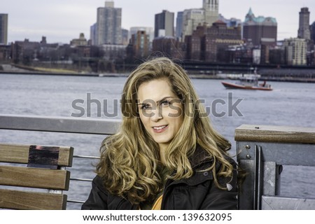Portrait of Young Woman. The background is a river and big city outline.