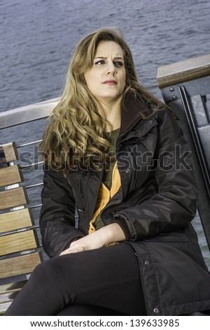 A unhappy woman is sitting by a river and trying to relax/Unhappy Woman