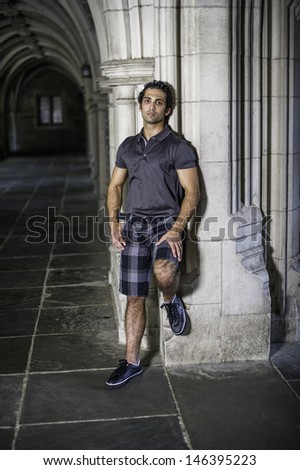 A young strong handsome guy is standing by a old fashion hall way, relaxing and thinking / Relaxing and Thinking