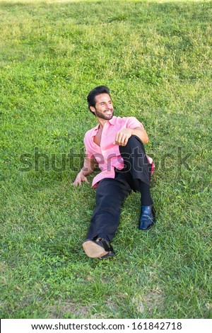 Dressing in a light red short sleeve shirt, black pants and leather shoes, a handsome, sexy, middle age guy with mustache and beard is lying on green grasses, relaxing. / Relaxing Outside