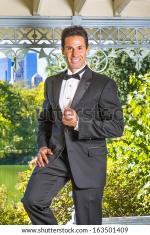 A professional executive is dressing in a black tuxedo, smilingly looking at you. / Portrait of Professional Executive