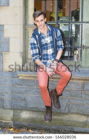 Dressing in a blue and white pattern shirt,  a blue hood vest,  red jeans and brown leather boot shoes, a young guy is sitting on the frame of the window, relaxing / Relaxing Outside