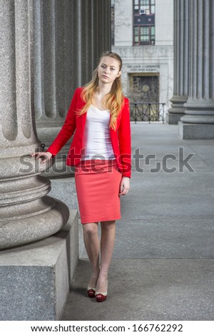 Dressing in a red blazer, white under wear, a red skirt and open toes high heels, a young blonde student is standing outside an office building. / Portrait of Young Student