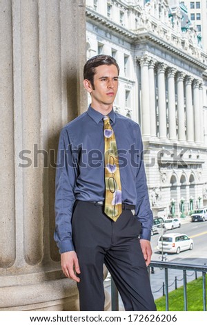Dressing in a blue shirt, black pants, a colorful tie, a young college student is standing outside an office building, sad, deeply thinking. / Thinking Outside
