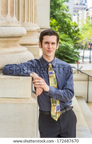 Dressing in a blue shirt, black pants, a colorful tie, a young college student is standing outside an office building, looking at you. / Portrait of College Student