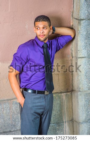 Dressing in a purple shirt, gray pants and a black tie, a hand putting in the back of his head, a hand putting in a pocket, a college student is leaning against the wall, frowned, waiting for you.