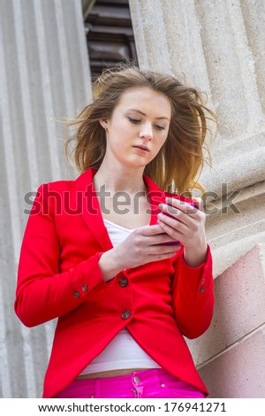 Wearing a red blazer, white underwear, hair floated in air,  a young teenager girl is busily checking messages on a smart phone in a windy day. / Text