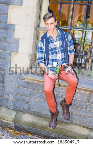 Young Man Waiting for You. Dressing in a pattern shirt,  a hood vest,  red jeans and brown leather boot shoes, a young guy is sitting by a window, holding a white flower, waiting for you.