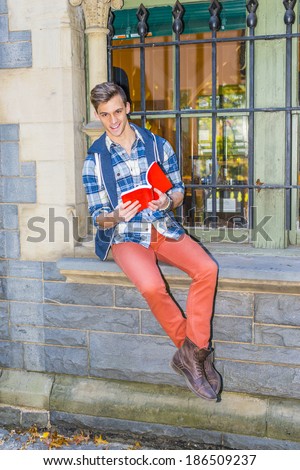 Man Reading Outside. Dressing in a blue and white pattern shirt,  a blue hood vest,  red jeans and brown leather boot shoes, a young guy is sitting by a window, reading a red book.