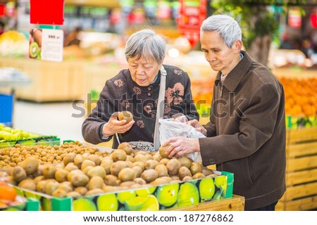 Senior Man and Woman Shopping Fruit. A  senior couple, 80 years old, is selecting fruits in a supermarket.