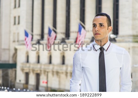 Portrait of Businessman. Dressing in a white shirt, a black tie, a young handsome man is standing outside a office building with USA flags, confidently looking forward.