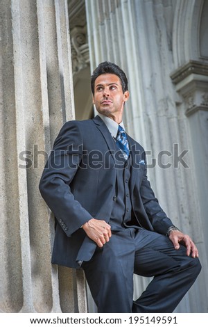 Man waiting for you. Dressing in dark blue suit, necktie, a handsome, sexy, middle age businessman is standing outside office, relaxing.