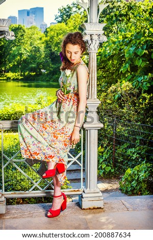 Lady Missing You. Dressing in sleeveless, light green, long dress, red sandals shoes, a pretty teenage girl is sitting inside a pavilion, hand holding a white rose, looking down, sad, thinking.