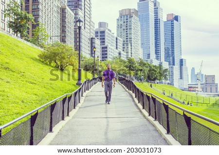 Road to Success. a young handsome man is confidently walking down on a road from a busy business district.