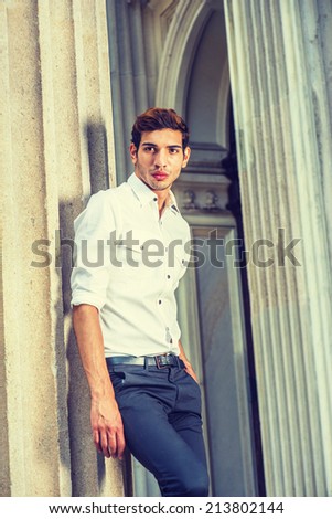Portrait of Young Businessman. Wearing a white shirt, black pants, a young college student is standing outside an office building, into deeply thinking.