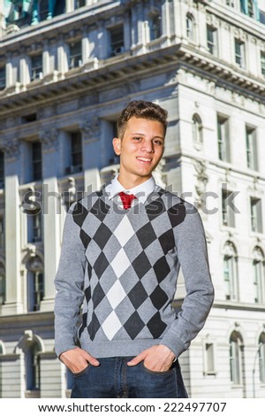 Portrait of College Student. Dressing in a black, white, gray patterned sweater, jeans, hands in pockets, a young handsome businessman is standing in the front of an office building, looking at you.