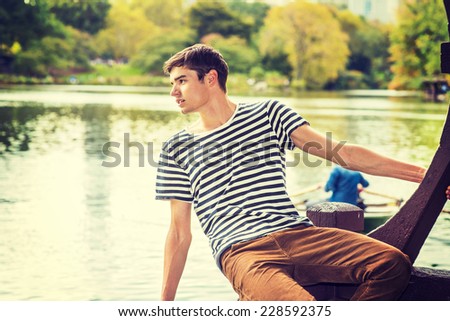 Man Waiting for You. Wearing a striped T shirt, brown corduroy pants, a young handsome guy is sitting by a lake, inclining half body, looking faraway, greeting You.