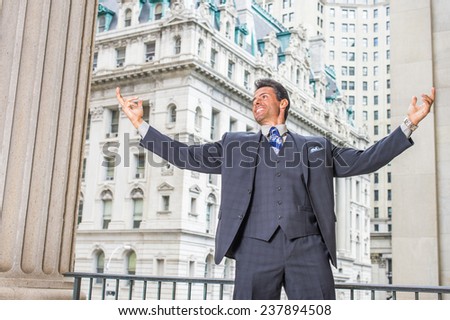 Man Power. Dressing in dark blue three piece suit, necktie, a handsome, sexy, middle age businessman is standing outside office building, stretching two arms, symbol of success.