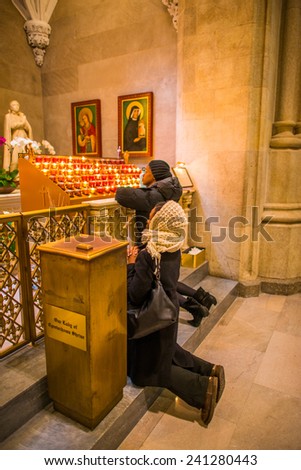 NEW YORK, NEW YORK - DECEMBER 25: Two women kneel down to pray at St. Patrick\'s Cathedral on December 25, 2014, Christmas, in Midtown of Manhattan.