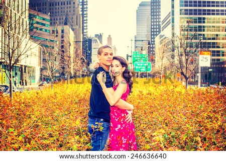 Valentine: Beginning of love story on warm vintage filtered look. Interracial young couple passionately hugging each other, standing at rose garden in the center of street on Manhattan, New York City.