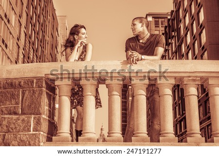 Living in harmony. Two friends standing by fence on street, facing each other, smiling, chatting in the front of neighborhood in a big city. Concept of relationship, communication between neighbors.