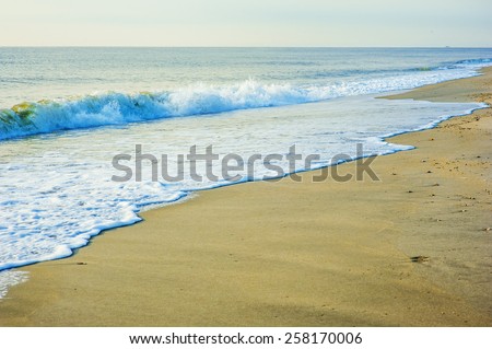 Early morning on Sandy Hook Beach, New Jersey, USA. Scenic view over Atlantic ocean,  sky, horizon, running waves over the shore. Instagram filtered look.