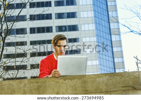 Man working remotely. Young blonde graduate student, wearing red sweater, frowned, working on laptop computer on the top of wall on school campus. Instagram filtered effect.