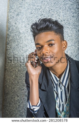 Portrait of School boy.  A young 18 years old black American college student with dental braces, smiling, making phone call on his mobile phone. Technology in our daily life. Close up, Head Shot.