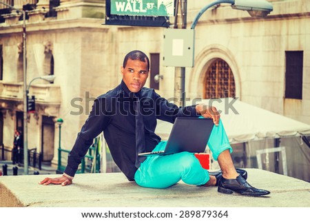 African American businessman with scar on his head, working on laptop computer on street in New York, Concept of facing reality, up and down, self assured, self esteem, confidence and success.