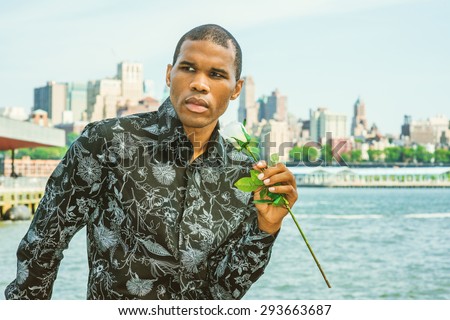 African American man with scar on his head seeking love in New York, holding a white rose, waiting for you. Concept of facing reality, up and down, self assured, self esteem, confidence and success.