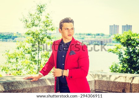 Businessman traveling in New York. Dressing in red blazer, blue collarless shirt, a young college student standing by Hudson River, opposite New Jersey,  confidently looking forward. Instagram effect.